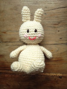 Der Amigurumi-Hase ist ganz weiß, und hat rosa Bäckchen